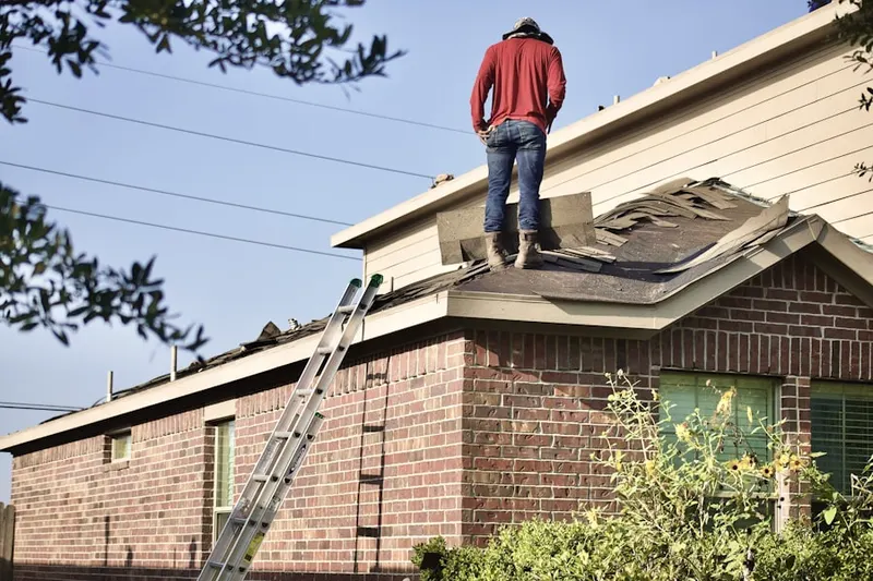 Professional roofer working on a residential roof in Upper